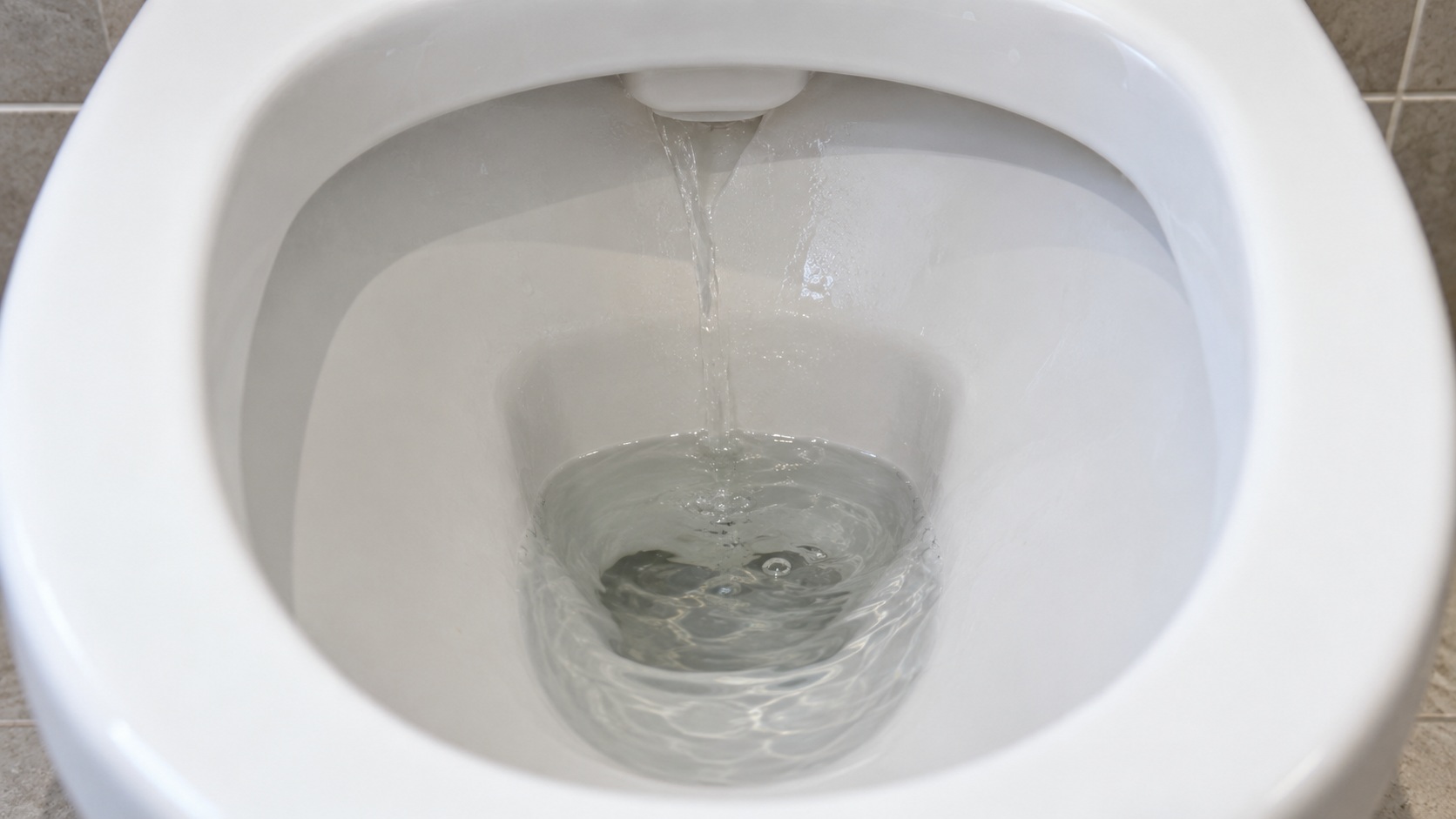 Inodoro de doble descarga con agua corriendo hacia la taza mientras se observa el pulsador y el nivel sin desmontar la cisterna